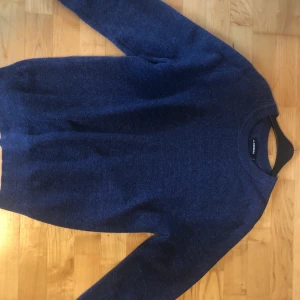 Stickad tröja från J.Lindeberg. Storlek M.  - Tröjan är marinblå och är ifrån J.Lindeberg och är i väldigt bra skick. Pris 480. Öppen för bud.