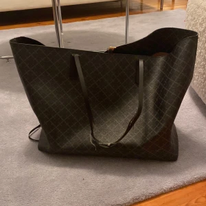 By Malene Birger  - By Malene Birger, Stor väska. Den är väl använd och ena axelremmen har gått av, Den andra lite trasig. Blixtlåset på innerfickan är går inte att stänga. Nypris ca 2600:- Går säkert att lämna in och fixa för den som vill. Mitt pris 250:-