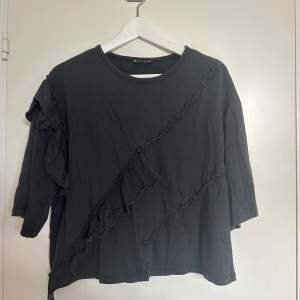 Jättecool t-shirt från Zara i storlek S. Mörkgrå (nästan svart). Volanger framtill. Frakt tillkommer 🖤 Fint skick. 