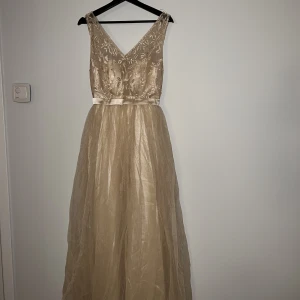 Bal/förlovningskläning  - Fin lång beige klänning som passar perfekt vid lite finare tillfällen. 