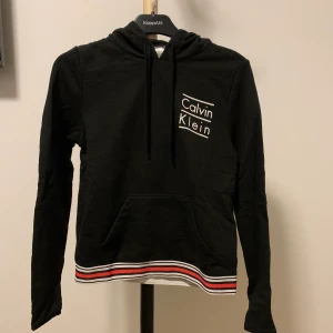 Calvin Klein hoodie - Svart Calvin Klein hoodie med fina detaljer. Storlek XS. Väldigt bra skick. Endast använd enstaka gånger. 