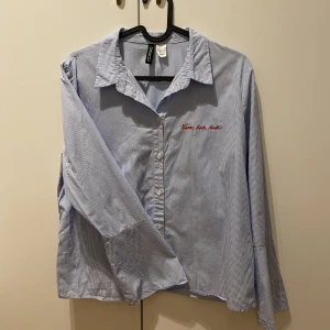 Skorta - Randig skotta med text på och utsvängda ärmar. Storlek 38