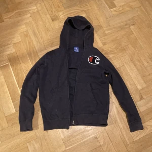 Champion Zip-Up Hoodie - Denna riktigt snygga champions hoodie har används några gånger men är nu för liten!   OBS! Det står XL i barnstorlek, skulle säga att den passar S!