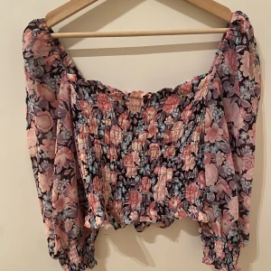 Topp - Rosa blommig topp som sitter superfint på kroppen! Den är mer klar i färgerna i verkligheten. 