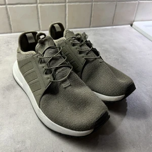  Adidasskor - Bekväma Adidasdojor utan snörning i en olivgrön färg. Varsamt använda, endast ett fåtal gånger inomhus. Unisex 