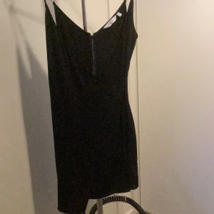 Svart klänning 3 - Fin omlottklänning m nära passform o dragkedja i rygg.