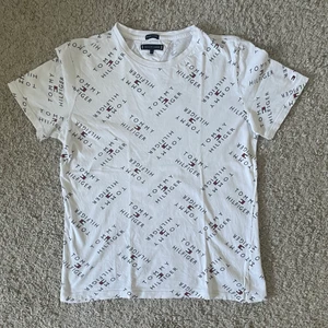 Tommy hilfiger T-shirt  - Vit Tommy hilfiger t-shirt med massa tryck på den i stl 176. Köparen står för frakten. Inget återköp 