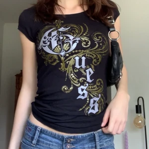 Guess-babytee - Liten svart t-shirt från Guess med tryck! Passar till lågmidjat 💕