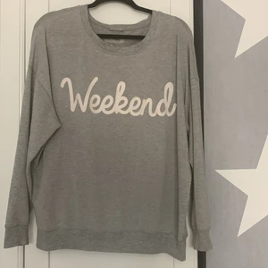 Grå tröja utan luva med weekend tryck. - Säljer dena gråa oversis  tröja för att den inte riktigt är min stil. Använt den runt 1 gång . Den är i väldigt. Bra skick och väldigt skönt material både utvändigt och invändigt .