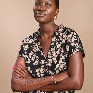 Blus/topp i nyskick  - Kortärmad topp med avslappnad passform, v-ringning och kort krage. Mjuk trikå baktill och framstycke i vävt tyg med heltäckande mönster. HÅLLBARHET. Detta plagg är delvis gjort i återvunnen polyester. När återvunnen polyester används innebär det att material som redan har producerats, som PET-flaskor, får en andra chans. Det är mycket mer resurseffektivt jämfört med att producera nytt material, vilket gör det bättre för miljön och minskar klimatpåverkan.  Avslappnad passform med rundad nederkant