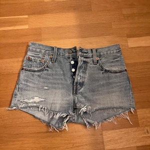 Levis shorts - Ett par jätte fina Levis shorts 501, väldigt korta. Dom är blåa i verkligheten men ser lite grå ut på bilden. Säljer för 100kr + frakt.