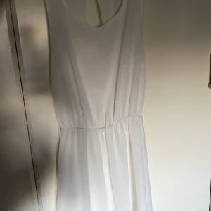 Vit klänning  - Vit simpelt men väldigt fin detalj där bak, storlek 34