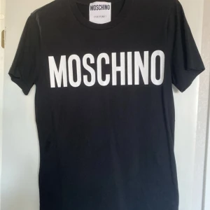 Moschino T-shirt  - Använd fåtal gånger, så den är i fint skick. Köpt på NK herravdelning, storlek eu 46. Passar xs, s även m, beroende på hur man vill att den ska sitta