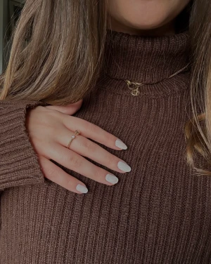 Brun stickad tröja  - Detta en en otrolig brun stickad tröja. Den är knappast använd. Tröjan är i en fantastik brun färg, har en polo krage och är ribbad.