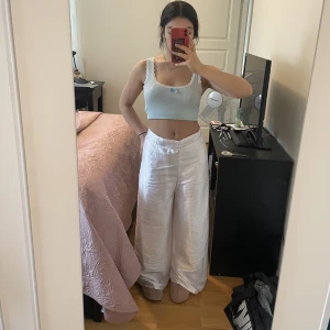 Satin byxor - Vita satin byxor med jättefint tryck. De är köpa utomlands och man kan knyta de hur man vill för att få olika modeller.