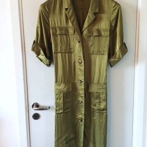 Skjortklänning 38 - Olivgrön klänning med knäppning fram och snöre baki   Silkigt material 