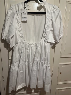 Klänning  - Vit klänning, volang, öppen rygg, snygg t sommaren eller studenten, storlek s, aldrig använd, prislapp hänger kvar!