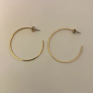 Guld örhängen  - Guldfärgade örhängen från H&M. Aldrig använda, inga skador! 