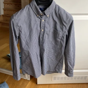 Gant skjorta  - I princip oanvänd pojkskjorta från Gant i storlek 158/164 säljes. Mörkblårutig Djur och rökfritt hem 