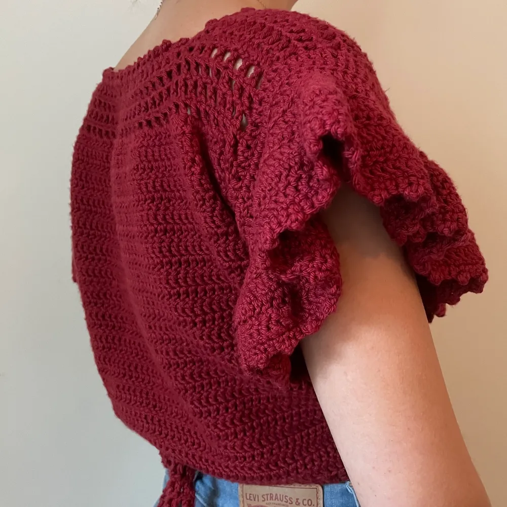 handmade wrap top, crocheted from 100% maroon/red soft cotton yarn (sourced in sweden). beautiful details: flared sleeves, textured edges, wrap around with tie in the back, mesh additions. the wrap around design allows it to fit different sizes. . Toppar.