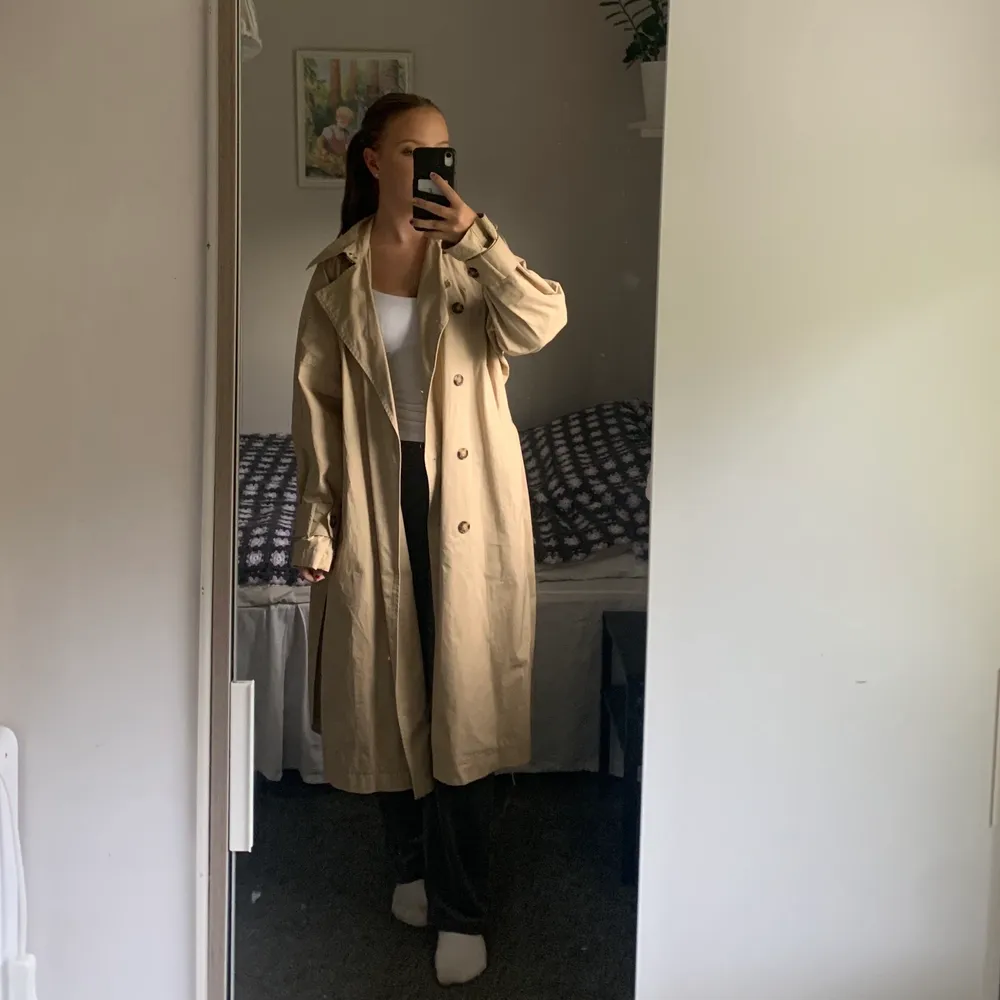 En beige trenchcoat från H&M. Perfekt till hösten🍂 Lång och bra Oversized på mig som vanligtvis bär XS. Inga defekter och knappt använd. Säljer för 200kr och köparen står för frakten💕😊. Jackor.