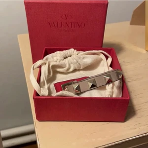 Valentino armband - Säljer mitt superfina valentinoarmband! Lite småslitningar här och där men inget man ser/förutom att det är en öppning i slutet av armbandet som lätt kan limmas igen och det syns inte när man har på sig det! Frakten är ej spårbar!