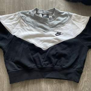 En snygg Nike croppad hoodie som är grå, vit och svart, tyvärr är den för liten för mig så jag säljer den💕