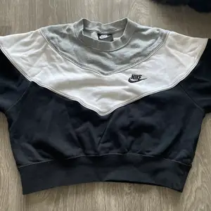 En snygg Nike croppad hoodie som är grå, vit och svart, tyvärr är den för liten för mig så jag säljer den💕