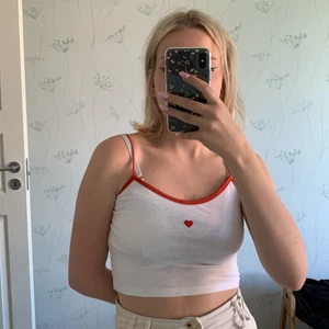 Vit topp med hjärta - Topp med ett gulligt rött hjärta mitt på. 