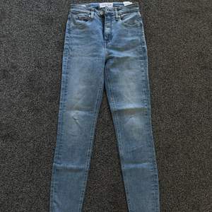 Skinny highwaisted jeans från Calvin Klein. Slitna detaljer nertill. Modell: High Rise Super Skinny Ankle. Storlek: 26 Jag är 158cm och längden på byxorna skulle jag säga är runt storlek längd: 29 eller 30. Använd fåtal gånger. Nypris 899kr