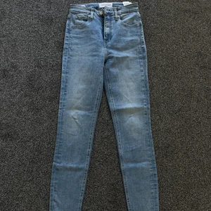 Skinny Jeans, Calvin Klein - Skinny highwaisted jeans från Calvin Klein. Slitna detaljer nertill. Modell: High Rise Super Skinny Ankle. Storlek: 26 Jag är 158cm och längden på byxorna skulle jag säga är runt storlek längd: 29 eller 30. Använd fåtal gånger. Nypris 899kr