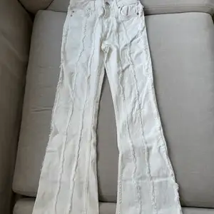 Vita ascoola jeans med ”fluffiga sömmar/linjer” längst med benen. Jeansen är high Waits och har 5 fickor och är stretchiga i materialet.  Aldrig använda och i nyskick med prislapp kvar