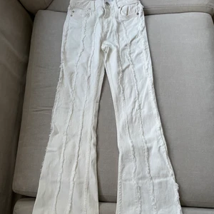 Vita flare jeans - Vita ascoola jeans med ”fluffiga sömmar/linjer” längst med benen. Jeansen är high Waits och har 5 fickor och är stretchiga i materialet.  Aldrig använda och i nyskick med prislapp kvar