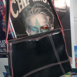 Svart och röd retro väska  - En svart retro väska med vita och röda sömmar med två st innerfack är