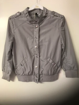 Grå jacka  - Tunn grå snygg jacka med halvlång ärm. Storlek 36.