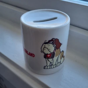 Spargris - En gulig switzerland spargris, med en saint bernad hund. 