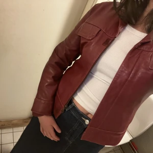 LÄDERJACKA röd - Svinsnygg läderjacka i fint skick säljes, inga skavanker eller dylikt. Strl: L, upplevs som en S/M beroende på hur man vill att den sitter. Snabb affär = pris kan diskuteras. Skickar ej via early bird då jag ska flytta. 