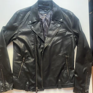 Jacka John Varvatos - Mått: M (jag är 185 cm) Skick: Oanvänd, köpt ny för dubbla priset Stil: Svart/mörkgrå bikerjacka i stretchig modal och polyester 