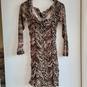 Leopars klänning  - Superfin, skön, sexig och helt ny klänning! Ruched mini klänning. Armarna är i mesh. Knytning vid bröstet. 