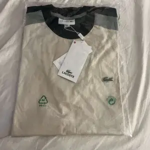 Säljer denna fina stilrena T shirt av märket Lacoste, aldrig använt med plasten och etiketten kvar. Kommer ej till användning så säljer den. Det är till herr 