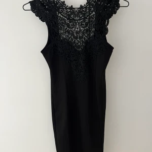 Klänning, strl XS - Kort Klänning med brodyr upptill och öppen rygg. Storlek XS/S Frakt ingår ej i priset. 