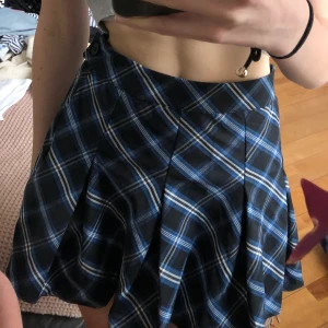 Rutig kjol - Blå svart rutig kjol från H&M. Aldrig använd med lappen kvar. Frakt tillkommer på 39kr! 