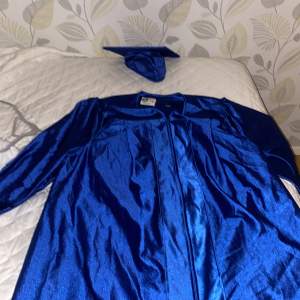 Blå graduation coat från engelska skolan. Använd 1gång, bra skick.  