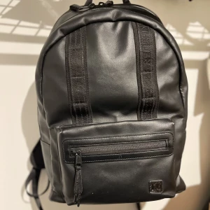 Db väska limited edition - Db väska, limited edition varav priset. Rymmer 16L, finns ett litet fack på utsidan, i det stora facket finns även en liten nätficka och sedan finns det ett enskilt datafack. Den är använd men i fint skick, finns lite läder släpp i kanterna nertill. 