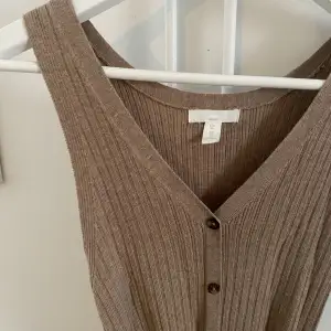 Stickad långklänning med knappar ifrån H&M. Passar mig som är en S. Fint skick. Beige/brun 