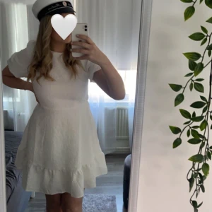 Vit klänning från vila  - En klänning perfekt till studenten eller till sommaren. Helt oanvänd. Jättefina detaljer i tyget samt en öppen rygg med en rosett i nacken   Nypris 499:-