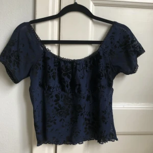 Söt blommig topp i mesh  - Söt blommig topp med jättefina detaljer från dELiA’s. Blommigt mönster i sammetliknande material. I övrigt är toppen i mesh ish. Bra skick. Frakt 30 kr😽