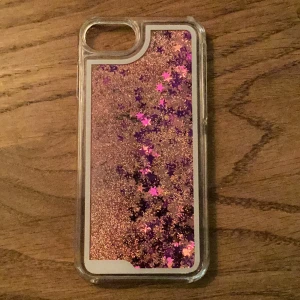 Glittrigt mobilskal med paljetter för iPhone SE, 7, 8 - Väldigt fint mobilskal med glitter och paljetter som kan röra sig. Mobilskalet passar dig som har en iPhone SE, 7, 8💗 Hör av dig om du gillar det och vill köpa.❤️Mobilskalet är i fint skick 