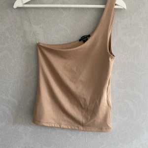 One shoulder topp  - Nudefärgad one shouldertopp Storlek: Small  Använd en gång 