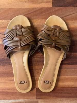 Bruna UGG sandaler  st40 som motsvarar 25,3cm. Använd två gånger. Perfekt skick, som nya.